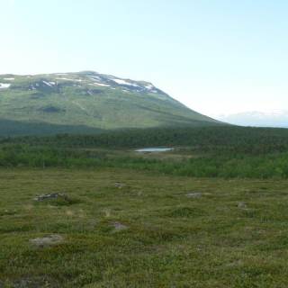 Photo d'une plaine avec des montagnes au loin et un lac minuscule au centre