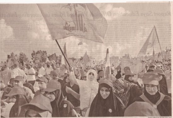 Photo de manifestants en gros plan dont une personne tient le drapeau du Hezbollah