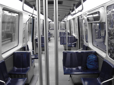 Intérieur d'un wagon du métro de Montréal avec les sièges bleu et le reste en noir et blanc