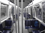 Intérieur d’un wagon du métro de Montréal avec les sièges bleu et le reste en noir et blanc